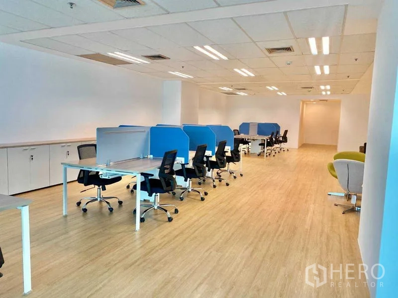 Office Space for rent - Deep office corridor with multiple workstation clusters, storage cabinets, and lounge chairs.