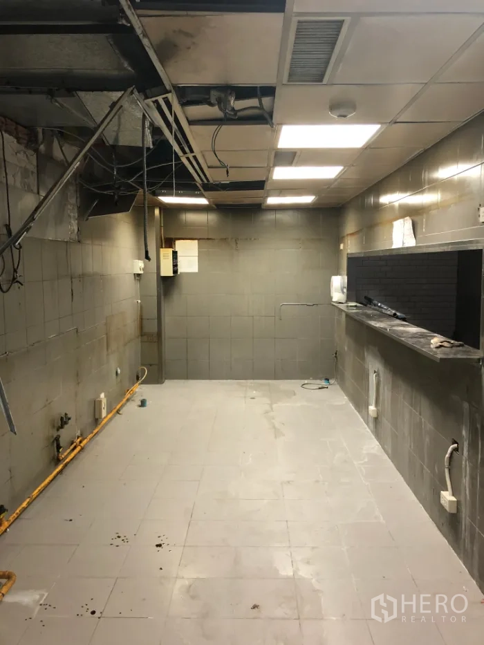 พื้นที่ขายปลีก ให้เช่าในKhlong Toei, Bangkok - ห้องเตรียมอาหารด้านหลัง ปูกระเบื้องสีเทา มีระบบงานบนฝ้าและจุดต่อสาธารณูปโภค