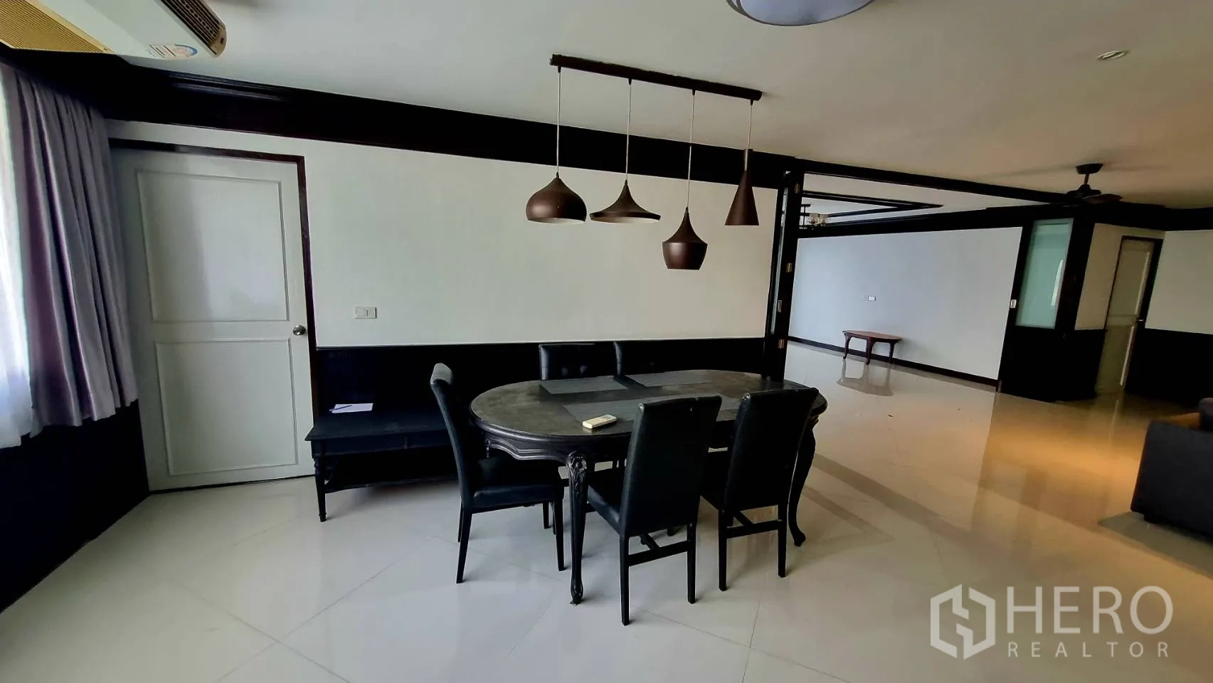 公寓 出租在Watthana, Bangkok - 六人餐桌，特色吊灯上方点缀。