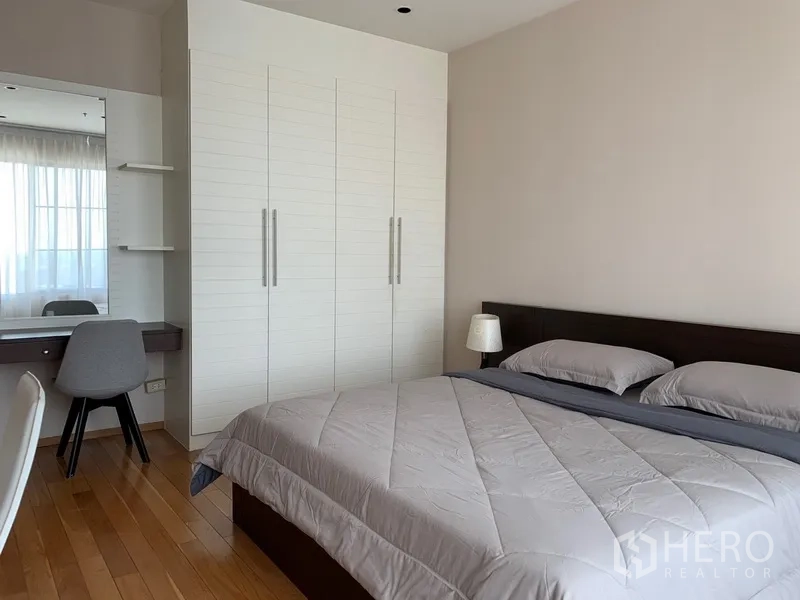 公寓 出租在Khlong Toei, Bangkok - 宽敞卧室，配备大床、白色通顶衣柜与梳妆台。