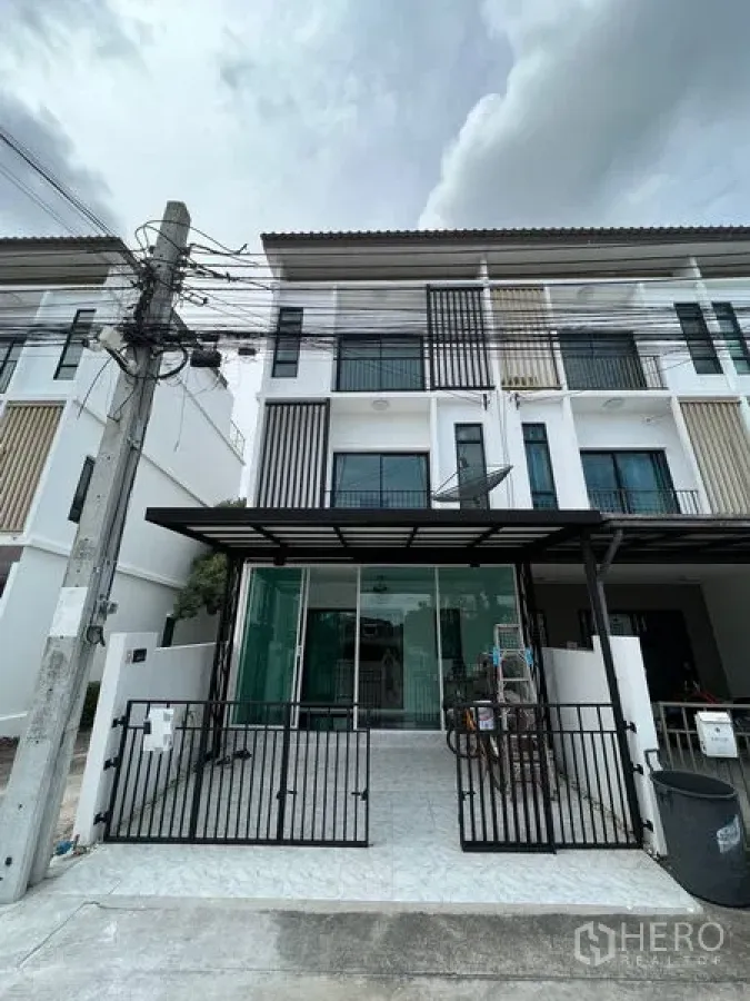 ทาวน์เฮาส์ ขายในBang Kapi, Bangkok - ด้านหน้าทาวน์เฮาส์ 3 ชั้นสไตล์โมเดิร์น มีกำแพงรั้วและโรงจอดรถ