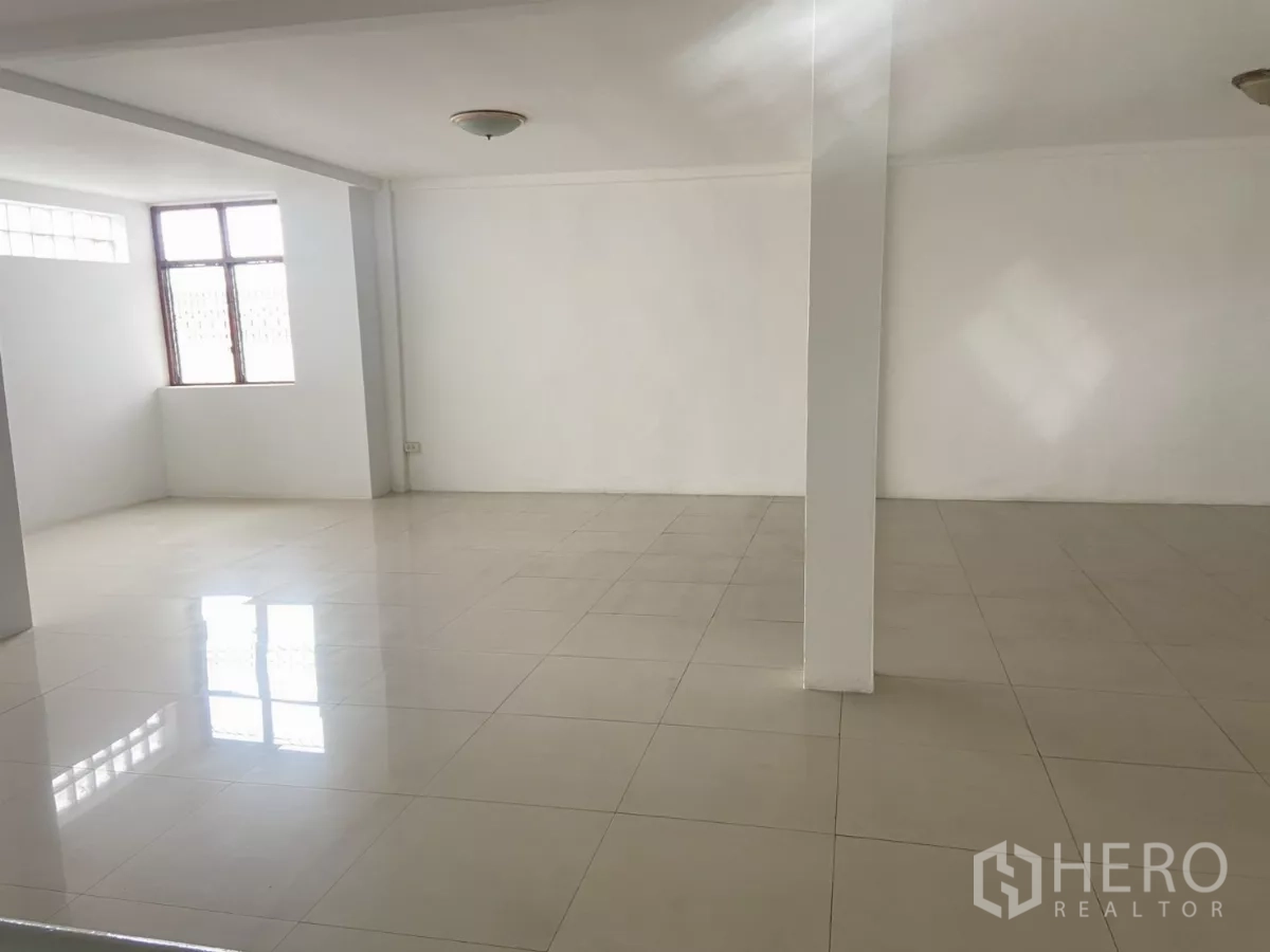 Shophouse for rent in Prawet, Bangkok - Open-plan floor with a central column and natural light from side windows.