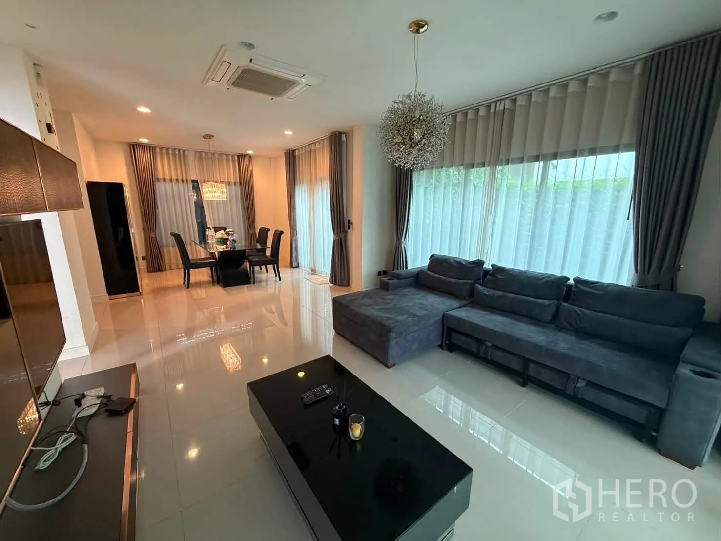 独栋房屋 for rent in Bang Kapi, Bangkok - 客厅明亮，超大L型沙发与宽幅窗户。