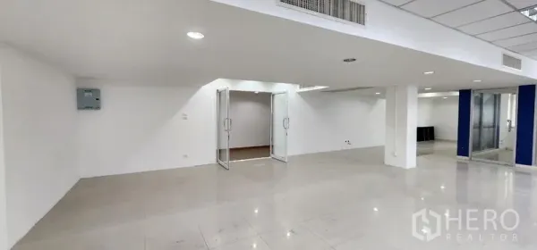 Office Space for rent in Chatuchak, Bangkok - Open work area featuring double glass doors, recessed lighting, and clean white walls.