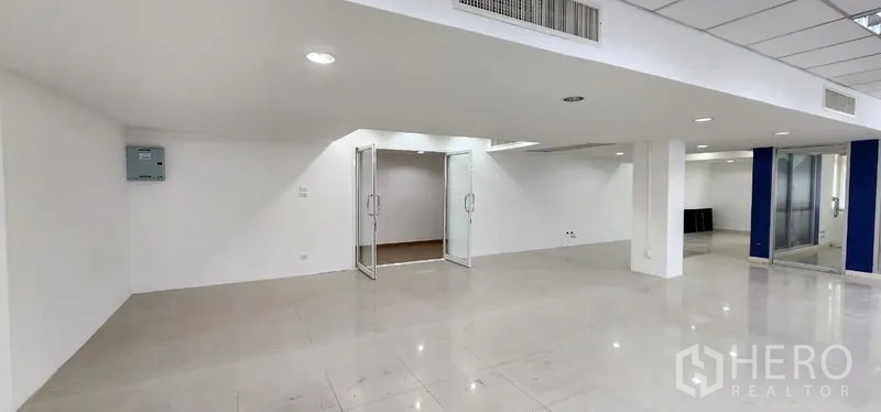Office Space for rent in Chatuchak, Bangkok - Open work area featuring double glass doors, recessed lighting, and clean white walls.