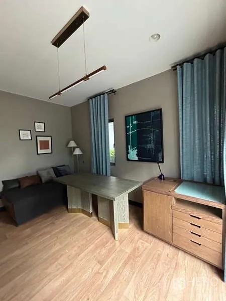 Detached House for rent in Bang Kapi, Bangkok - Home office with large desk, sofa, wood floors and tall curtains.