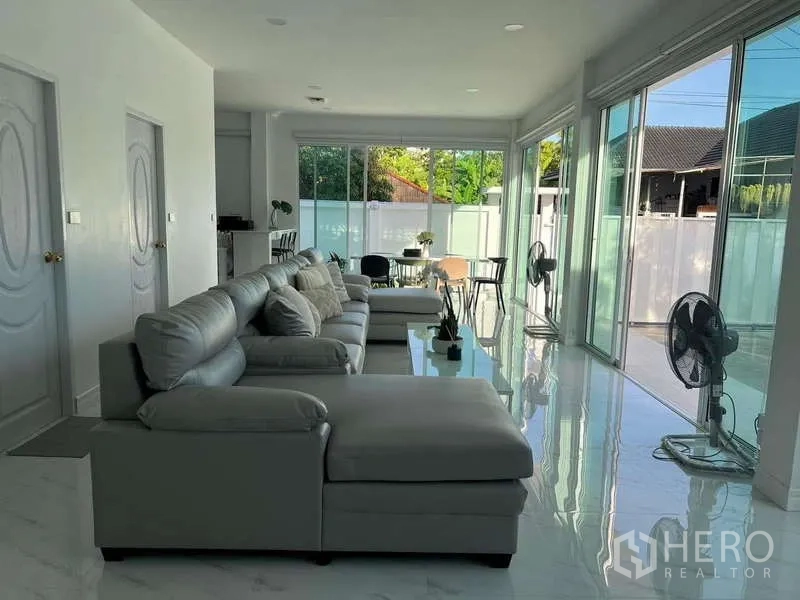 บ้าน ให้เช่าในLat Krabang, Bangkok - ห้องนั่งเล่นแบบโอเพ่นแพลน โซฟาตัวยาว และประตูกระจกบานเลื่อนสูงจรดเพดาน