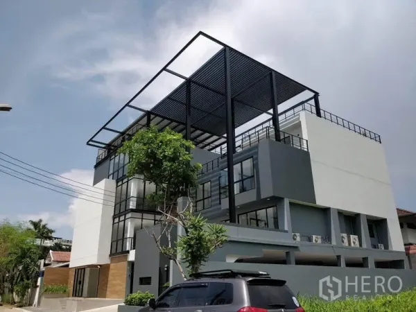 Office Space for rent in Prawet, Bangkok - Corner view of the multi-storey office with steel rooftop frame and on-site parking.