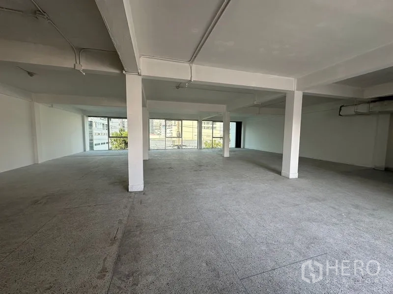 Office Space for rent in Khlong Toei, Bangkok - Spacious office interior facing floor-to-ceiling windows with city views and abundant daylight.