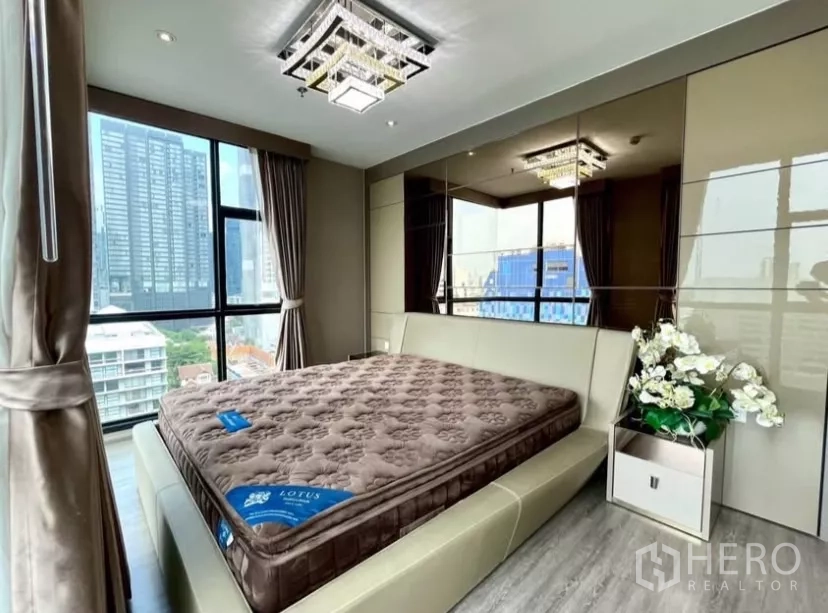 คอนโด ให้เช่าในWatthana, Bangkok - ห้องนอนมาสเตอร์ เตียงใหญ่ ตู้เสื้อผ้าเงา และหน้าต่างสูงมองเห็นตึกเมือง