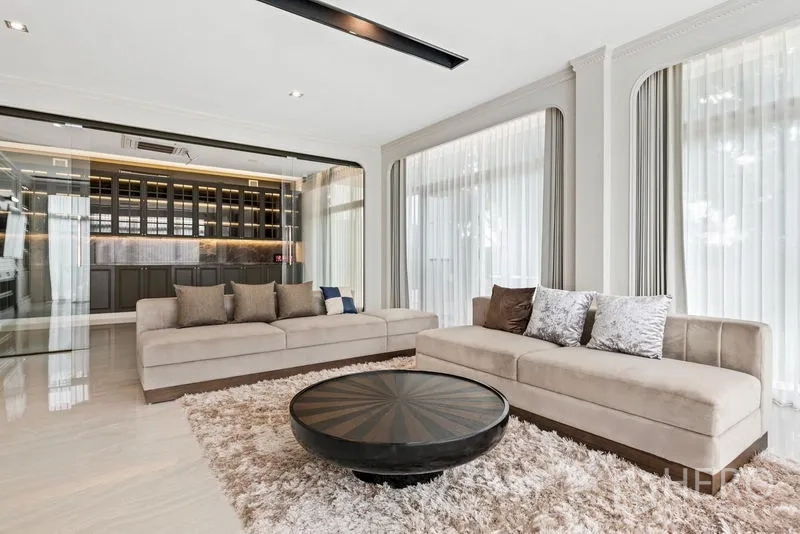 บ้าน ขาย - มุมนั่งเล่นโซฟาสองตัว พรมขน และผนังบานกระจกกั้นกับบาร์