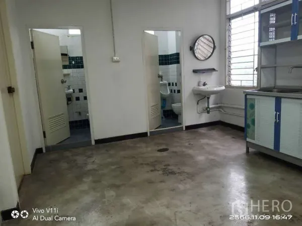 Office Space for rent in Bang Na, Bangkok - Pantry area with wall-mounted sink, cabinet and two restroom doors.