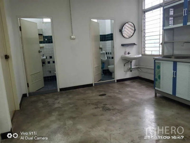 Office Space for rent in Bang Na, Bangkok - Pantry area with wall-mounted sink, cabinet and two restroom doors.