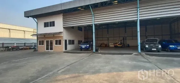 货栈 出租在Khlong Luang, Pathum Thani - 带卷帘门的有顶装卸月台，前方设有小型办公室。