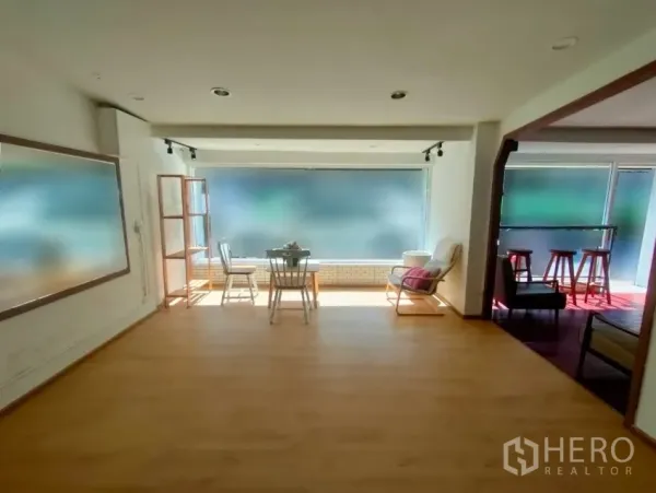 零售空间 出租在Khlong Toei, Bangkok - 临街前厅，磨砂大窗、木地板与座椅。