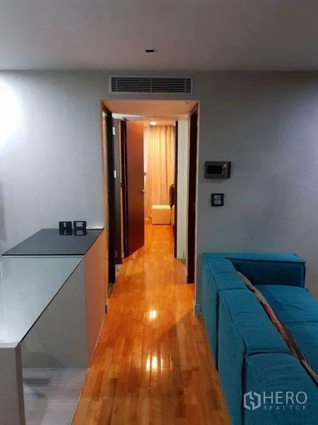 Condominium for sale in Bang Rak, Bangkok - Hallway from living zone leading to bedrooms over warm wooden floors.