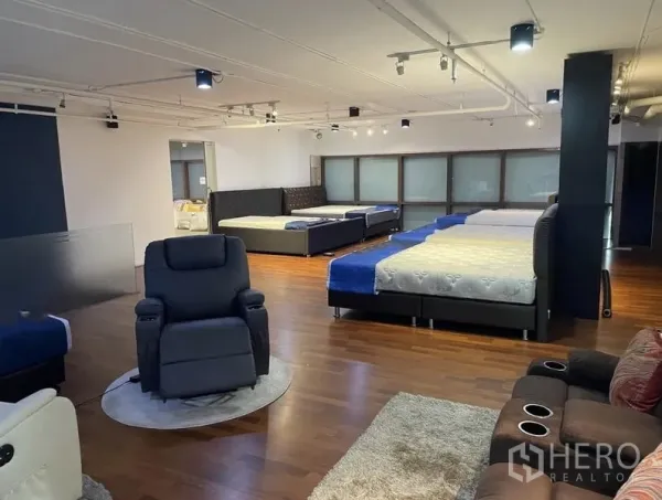 พื้นที่ขายปลีก ให้เช่า - ชั้นโชว์รูมสว่าง แบ่งโซนจัดแสดง เก้าอี้พักผ่อน ไฟสปอตไลท์ พื้นไม้