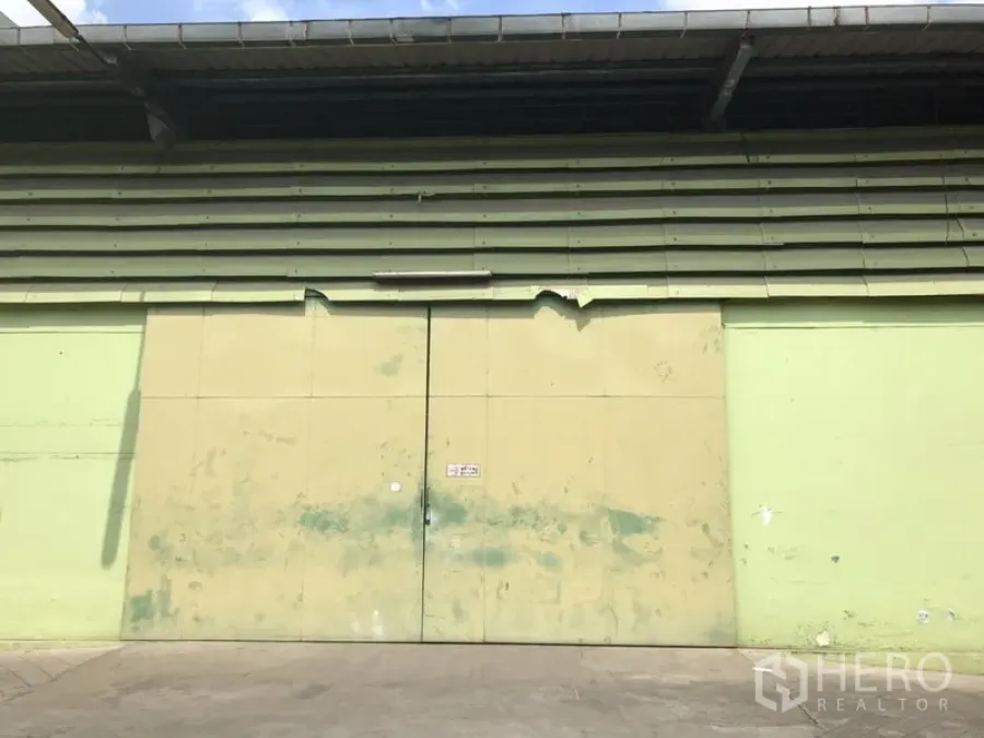 คลังสินค้า ให้เช่าในKhlong Toei, Bangkok - ประตูเหล็กบานคู่ขนาดใหญ่ของโกดัง ใต้ชายคายื่นยาว