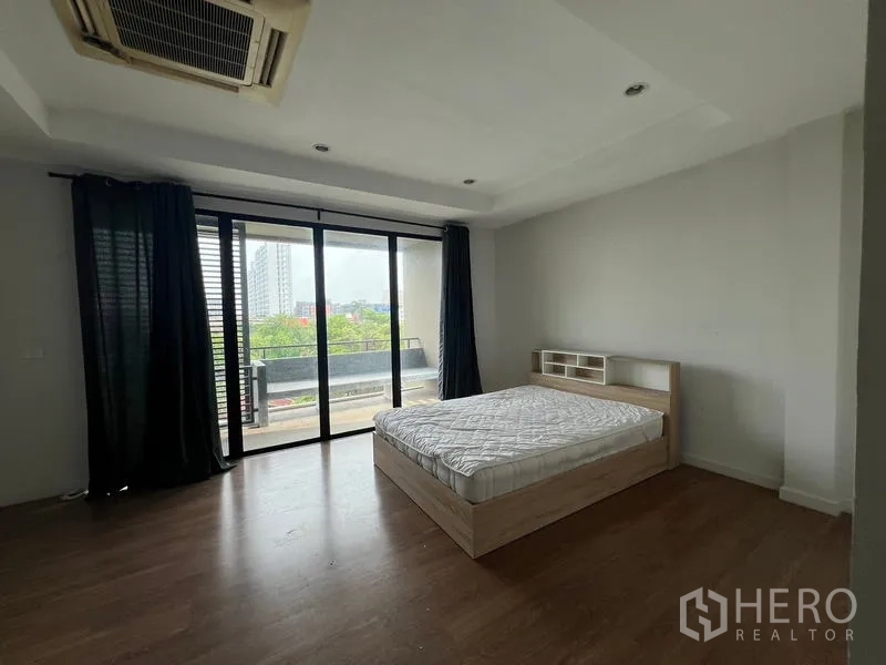 ทาวน์เฮาส์ ให้เช่าหรือขายในKhlong Toei, Bangkok - ห้องนอนใหญ่เปิดสู่ระเบียง มองเห็นวิวเมือง พื้นไม้