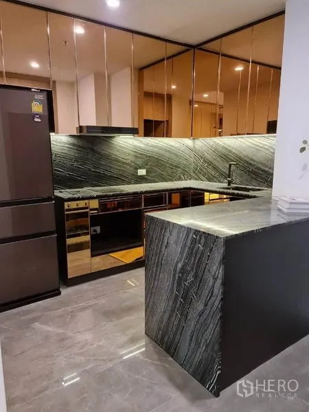 คอนโด ขายในPathum Wan, Bangkok - มุมครัวโชว์ไอส์แลนด์หิน เตาอบบิลท์อิน ผนังกันเปื้อนหิน และตู้เย็น