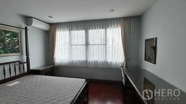 公寓 出租在Sathon, Bangkok - 采光充足的卧室，落地窗帘、床与长书桌。