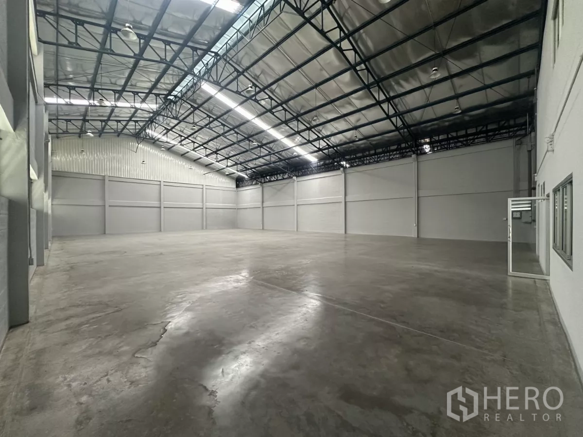 Factory for rent in Bang Phli, Samut Prakan - Large empty warehouse with polished concrete floor and high insulated steel roof.