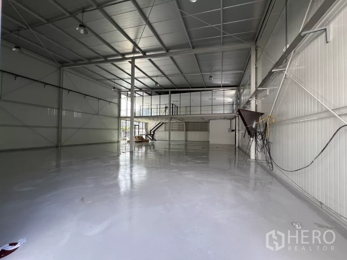 Warehouse for rent in Bang Na, Bangkok - Spacious warehouse interior with high ceiling, polished epoxy floor, and mezzanine glass office.