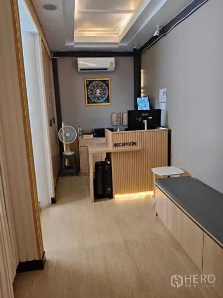 Retail Space for rent in Khlong Toei, Bangkok - Small reception area with desk, computer and seating in light wood tones.