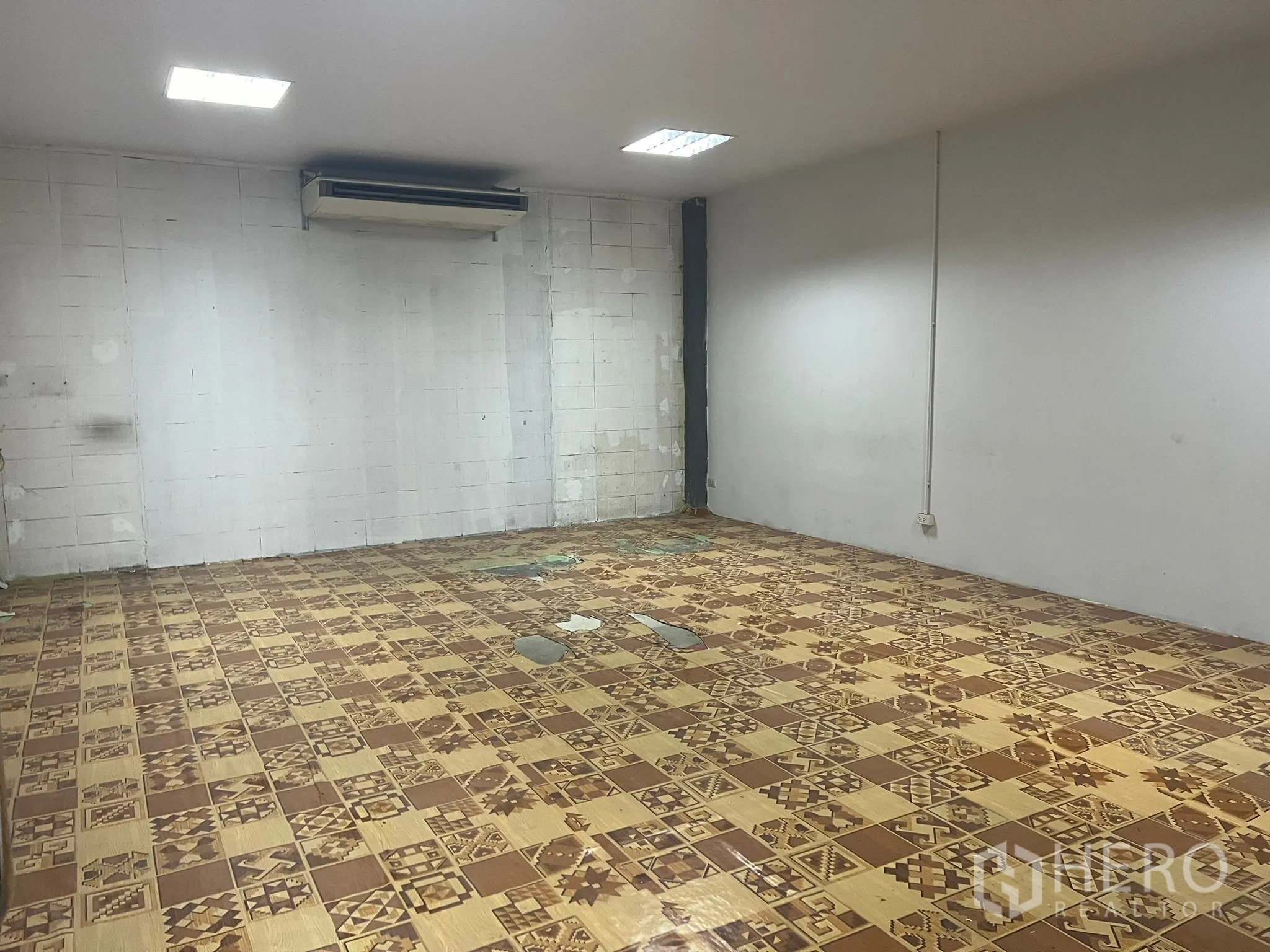 Factory for rent in Bang Pakong, Chachoengsao - Second office room with AC unit and vintage patterned tile flooring.