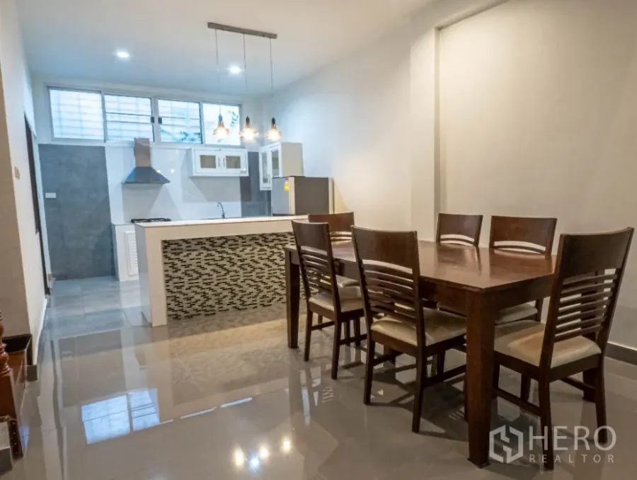 ทาวน์เฮาส์ ให้เช่าในKhlong Toei, Bangkok - พื้นที่รับประทานอาหารแบบเปิดพร้อมโต๊ะไม้ 6 ที่นั่งและครัวไอส์แลนด์พร้อมโคมแขวน