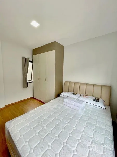 Townhouse for rent in Bang Phli, Samut Prakan - Third bedroom with bed, wardrobe and warm wood floors.