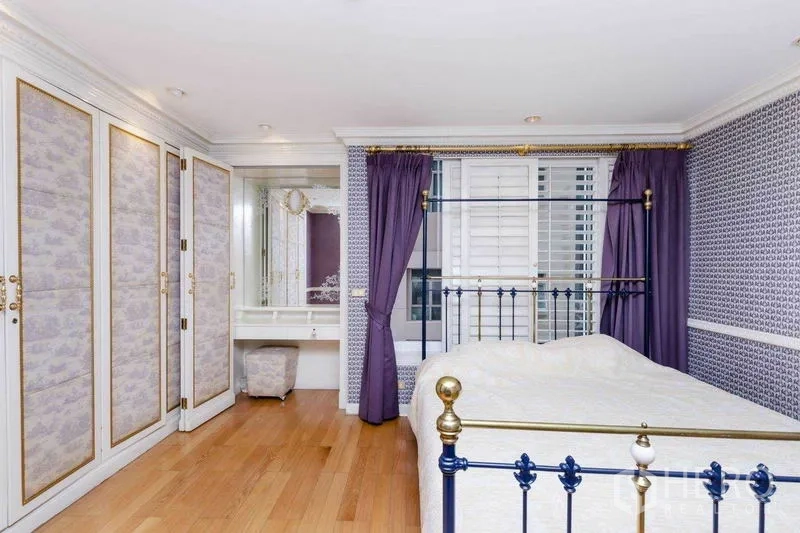Condominium for rent or sale in Pathum Wan, Bangkok - Elegant bedroom with metal bedframe, purple drapes, patterned walls, and built-in wardrobe.