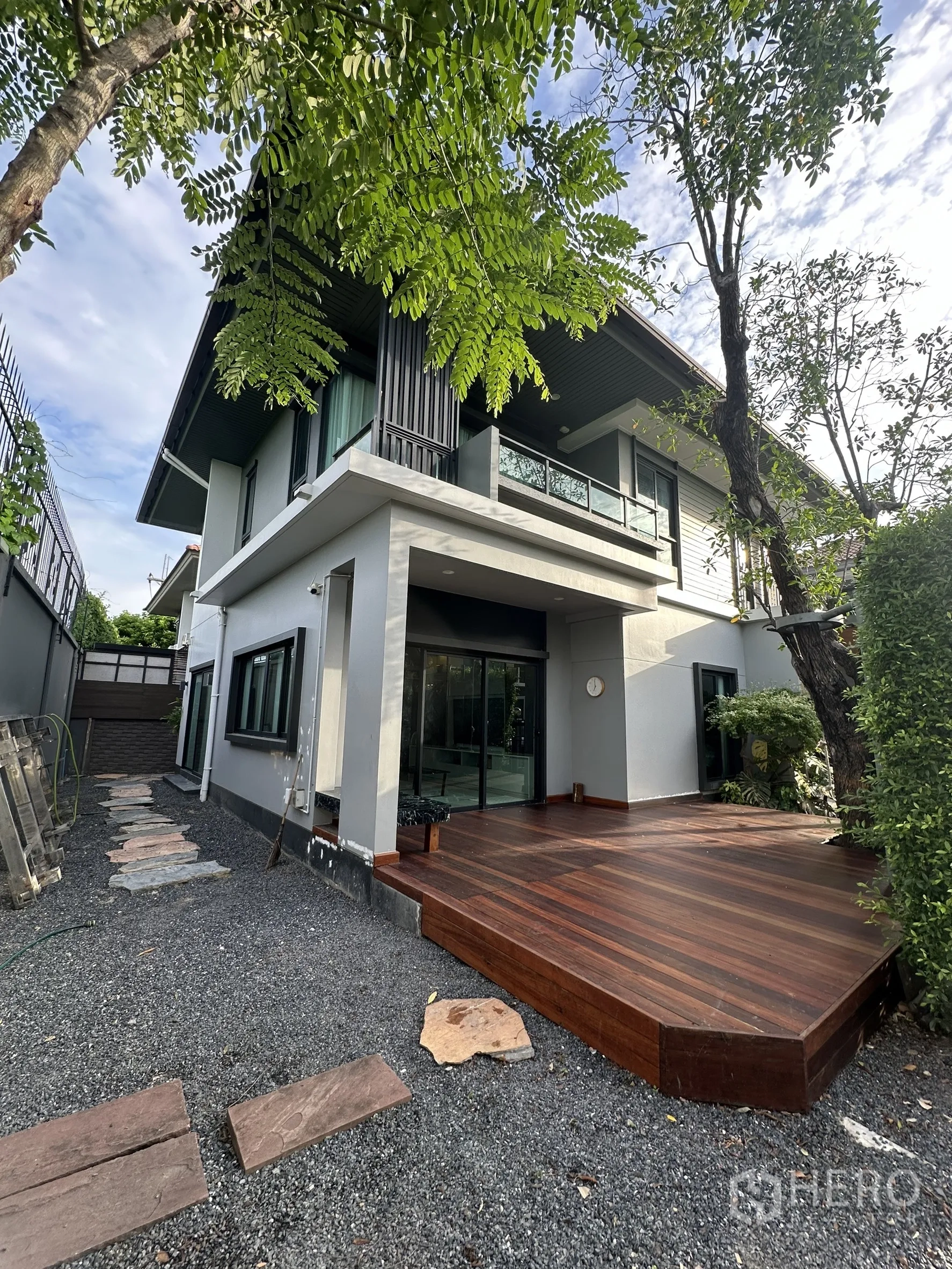 บ้าน ให้เช่าหรือขายในLam Luk Ka, Pathum Thani - ชานไม้ภายนอกขนาดใหญ่ข้างตัวบ้าน เชื่อมประตูกระจกบานเลื่อน รายล้อมด้วยต้นไม้