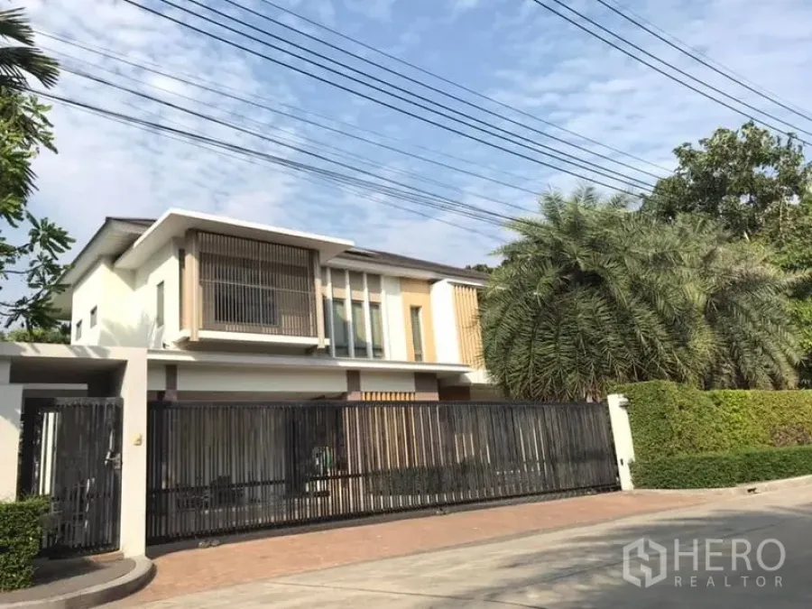 独立式住宅 出售在Saphan Sung, Bangkok - 街景外观：当代两层住宅，长金属围栏与绿化