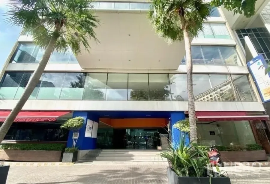 零售空间 出租 - 商用建筑街景外立面，大面积玻璃窗、遮阳篷与绿植。