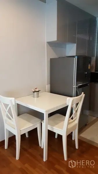คอนโด ให้เช่าในWatthana, Bangkok - มุมรับประทานอาหารเล็ก โต๊ะสีขาวกับเก้าอี้สองตัว ข้างครัว พื้นไม้