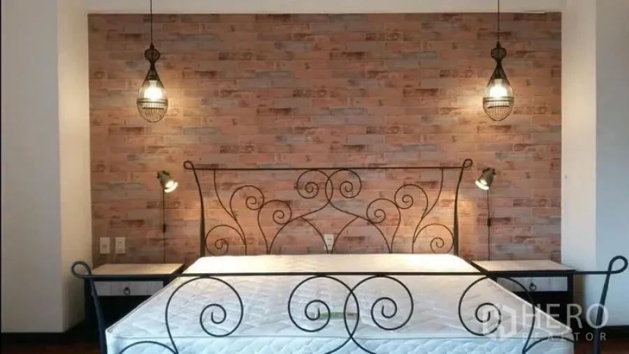 公寓 出租在Khlong Toei, Bangkok - 卧室配锻铁床架与红砖特色墙，吊灯和双边床头柜。
