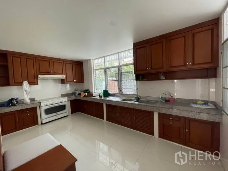 บ้าน ให้เช่าในKhlong Toei, Bangkok - ครัวปิด เคาน์เตอร์หินแกรนิตยาว ตู้ไม้ เตาอบ และหน้าต่างบานใหญ่