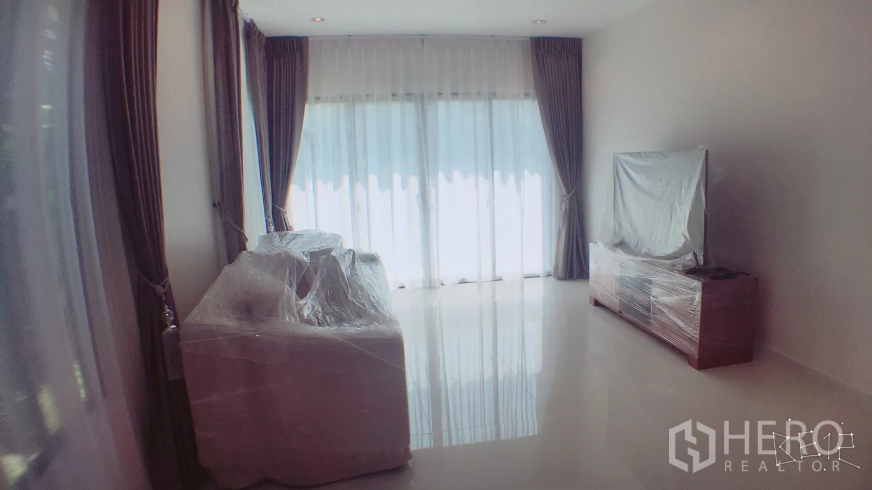 Detached House for rent in Suan Luang, Bangkok - Spacious living room with sliding glass doors, wrapped sofa and TV console, and abundant natural light.