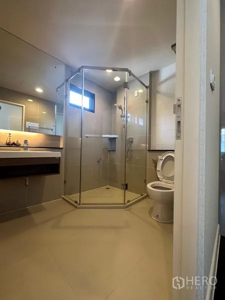 บ้าน ให้เช่าหรือขายในLam Luk Ka, Pathum Thani - ห้องน้ำตกแต่งโทนอบอุ่น พร้อมตู้กระจกกั้นอาบน้ำ อ่างล้างหน้า และโถสุขภัณฑ์