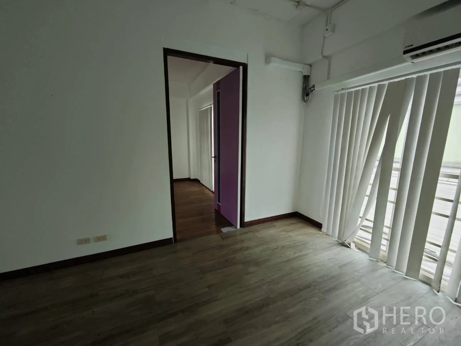 Office Space for rent in Prawet, Bangkok - Compact meeting room with vertical blinds, split-type air conditioner and wood-look floor.