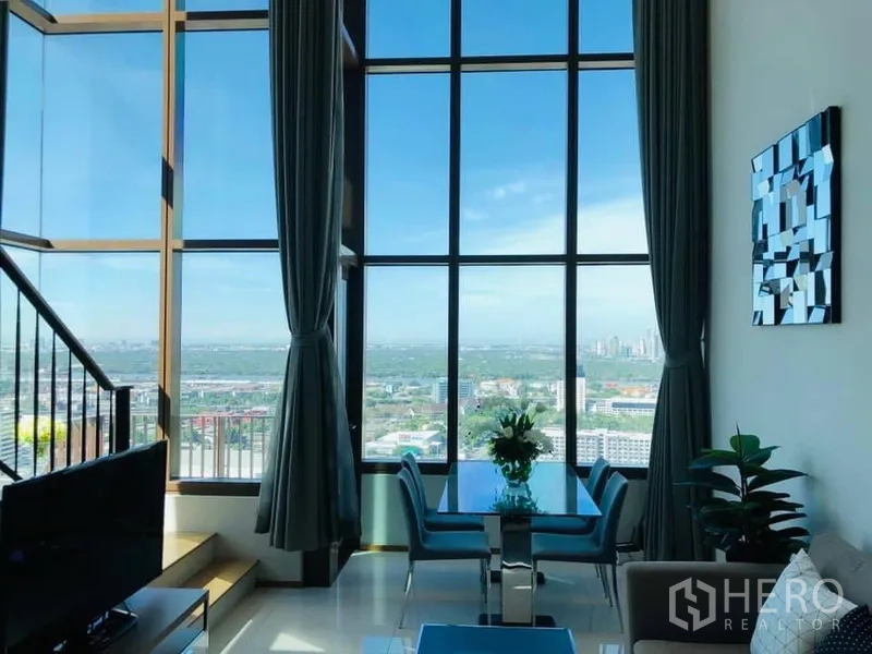 คอนโด ให้เช่าในKhlong Toei, Bangkok - พื้นที่รับประทานอาหารและนั่งเล่นสว่างไสว มุมมองสกายไลน์ผ่านหน้าต่างสูง พร้อมบันได ในคอนโดคลองเตย