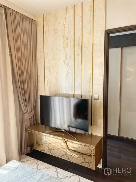 คอนโด ให้เช่าหรือขายในWatthana, Bangkok - ผนังทีวีลายหินอ่อนแต่งเส้นสีทองพร้อมตู้วางทีวีกระจกในโซนรับแขก
