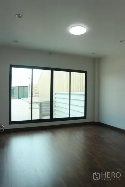 Factory for sale in Bang Pakong, Chachoengsao - Private office room with wood floors and a large window overlooking the yard.