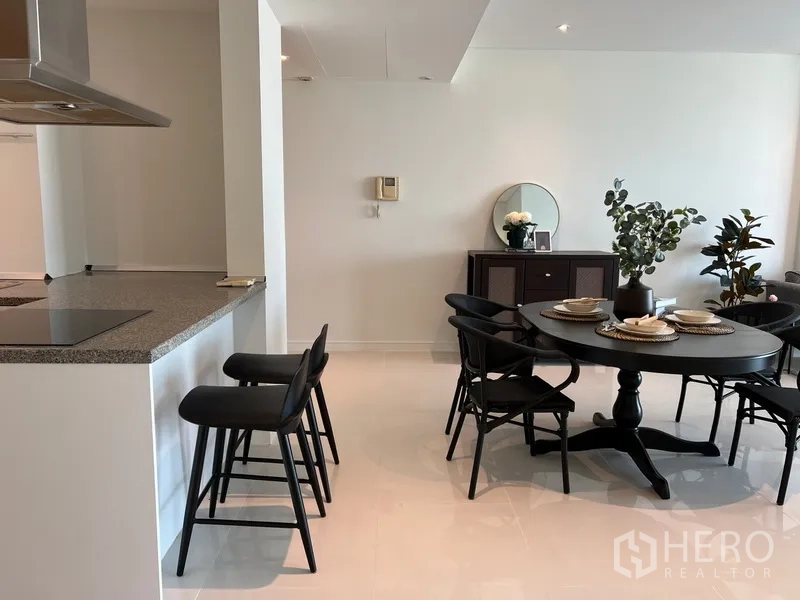 คอนโด ให้เช่าในKhlong Toei, Bangkok - ไอส์แลนด์ครัวพร้อมสตูลบาร์ ถัดจากชุดโต๊ะอาหารสีดำและตู้ลิ้นชัก