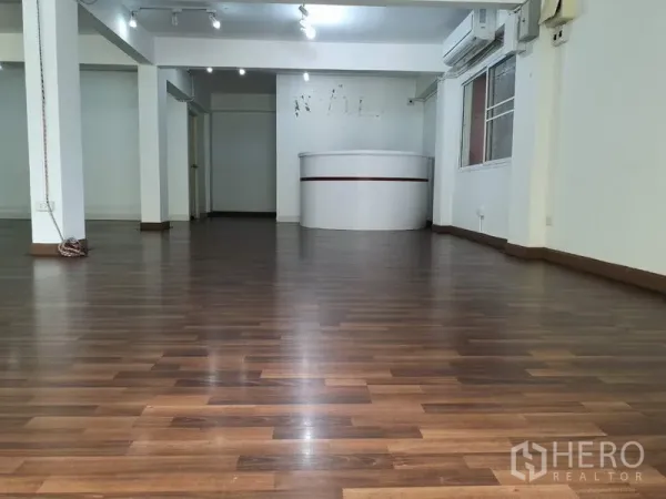 Office Space for rent in Khlong Toei, Bangkok - Open-plan office in Phra Khanong with wood flooring, track lights and a curved reception counter.