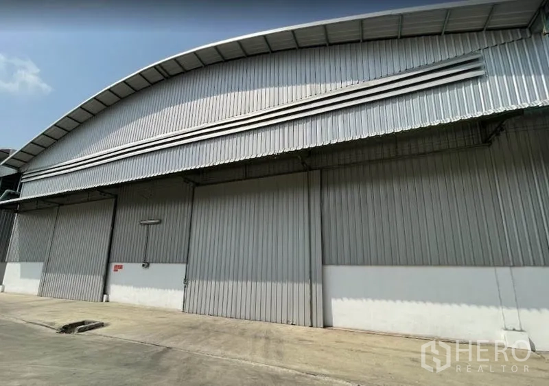 货栈 出租在Bang Pa-in, Phra Nakhon Si Ayutthaya - 大城府邦巴茵金属板仓库外立面，拱形屋顶与大尺寸滑动门。