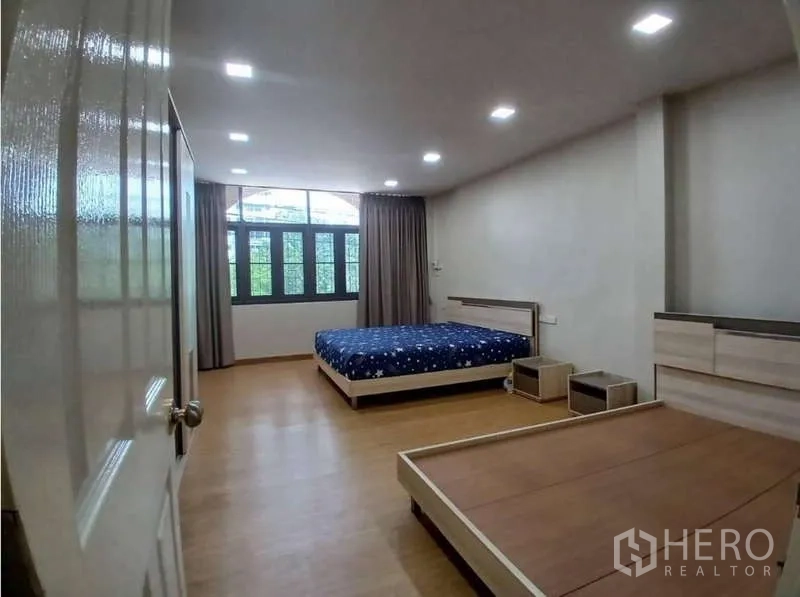 อาคารพาณิชย์ ให้เช่าในPhra Khanong, Bangkok - ห้องนอนกว้าง พื้นไม้ หน้าต่างบานใหญ่พร้อมผ้าม่าน และเฟอร์นิเจอร์เตียงและโต๊ะข้าง