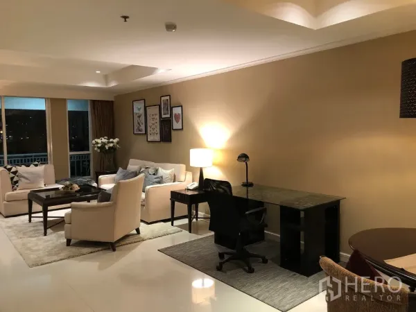 Condominium for rent in Watthana, Bangkok - Living room with comfortable seating and a dedicated home office desk and task lamp.