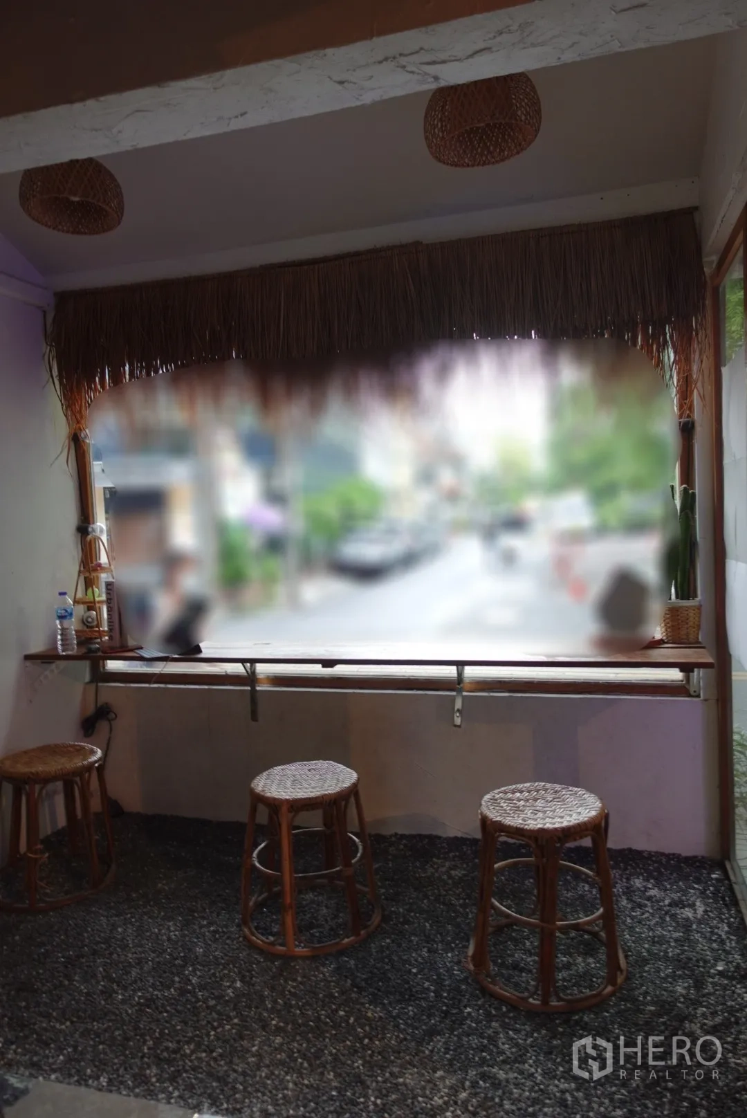 零售空间 出租在Khlong Toei, Bangkok - 靠窗吧台与藤编圆凳，可眺望街景的店面区域